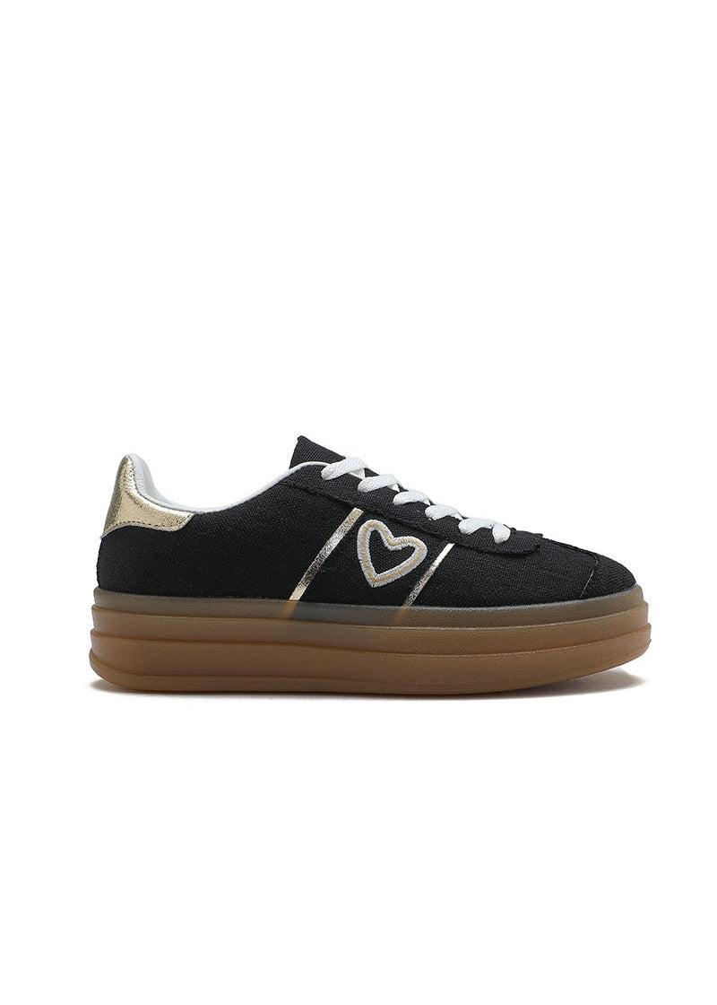 Baskets noires pour femme avec semelle plateforme beige, lacets blancs, cœur doré brodé sur le côté et détail métallisé au talon. Modèle confortable et tendance signé Timalya prêt-à-porter.
