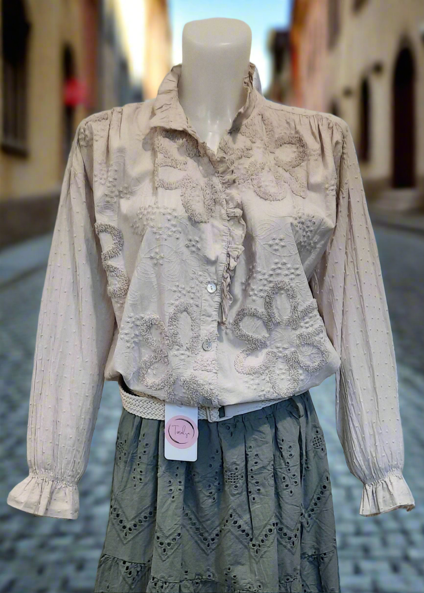 Blouse romantique beige pour femme avec broderies florales en relief et col à volants – manches longues bouffantes et fermeture boutonnée, parfaite pour un look chic et bohème.