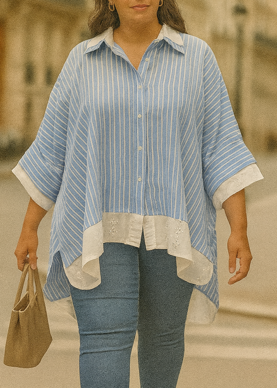 Chemise ample femme bleu ciel à rayures blanches, col classique, manches 3/4 boutonnées, détails en broderie anglaise blanche sur le col, les poignets et le bas.