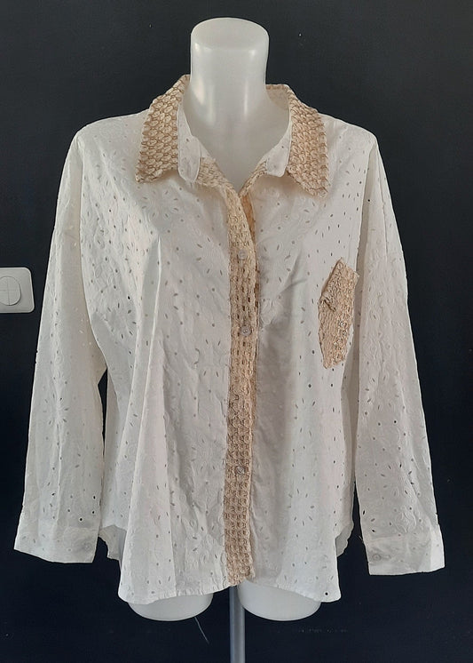 Chemise blanche en broderie anglaise pour femme, col, patte de boutonnage et poche en crochet doré. Coupe fluide et détails bohèmes raffinés.