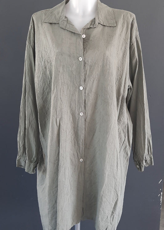 Chemise longue kaki pour femme, à manches longues, col classique, tissu effet froissé légèrement texturé avec motif écritures, boutonnage sur le devant.