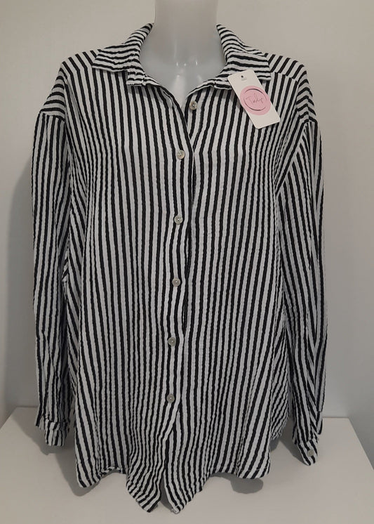 Chemise femme à rayures verticales noires et blanches en gaz de coton, coupe classique à col chemise et manches longues – un essentiel chic et intemporel pour un look professionnel ou décontracté.