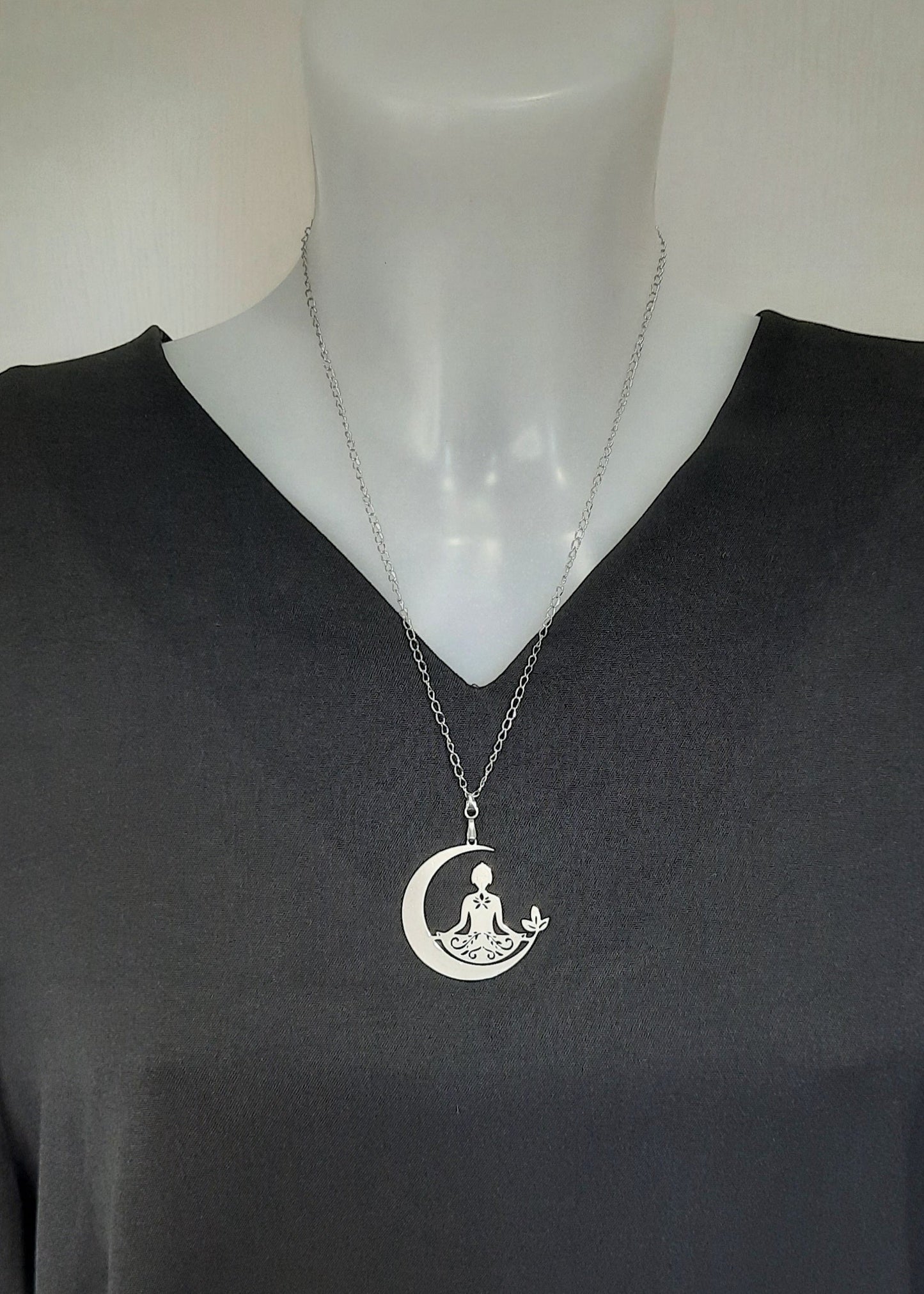 Collier bouddha en acier inoxydable argenté, représentant une silhouette en méditation sur un croissant de lune avec décor floral, bijou zen et résistant