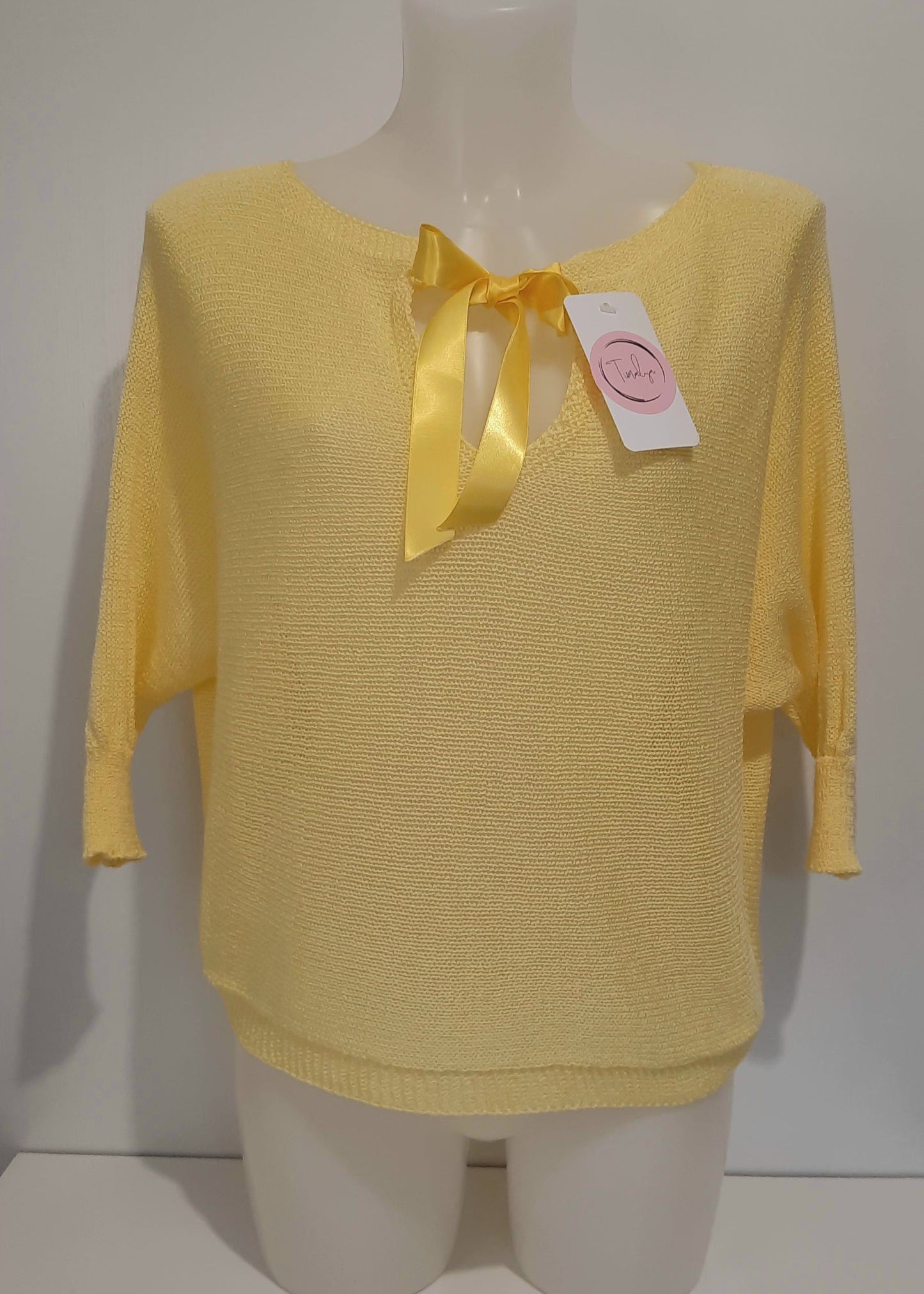 Haut en maille fine jaune pastel pour femme, manches 3/4 chauve-souris et encolure bateau. Coupe fluide et légère, parfaite pour le printemps ou l’été.