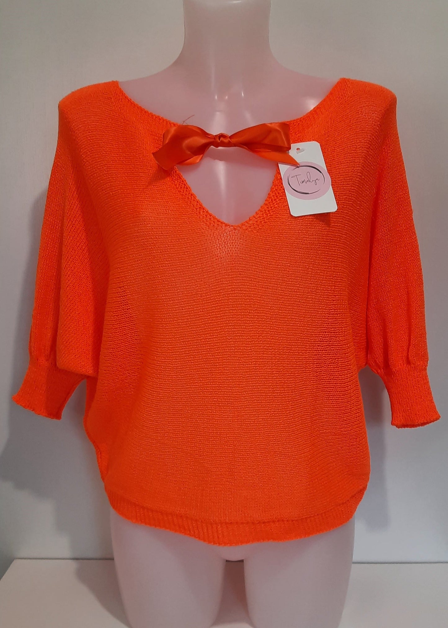 Haut en maille fine orange pour femme, manches 3/4 chauve-souris et encolure bateau. Coupe fluide et légère, parfaite pour le printemps ou l’été.