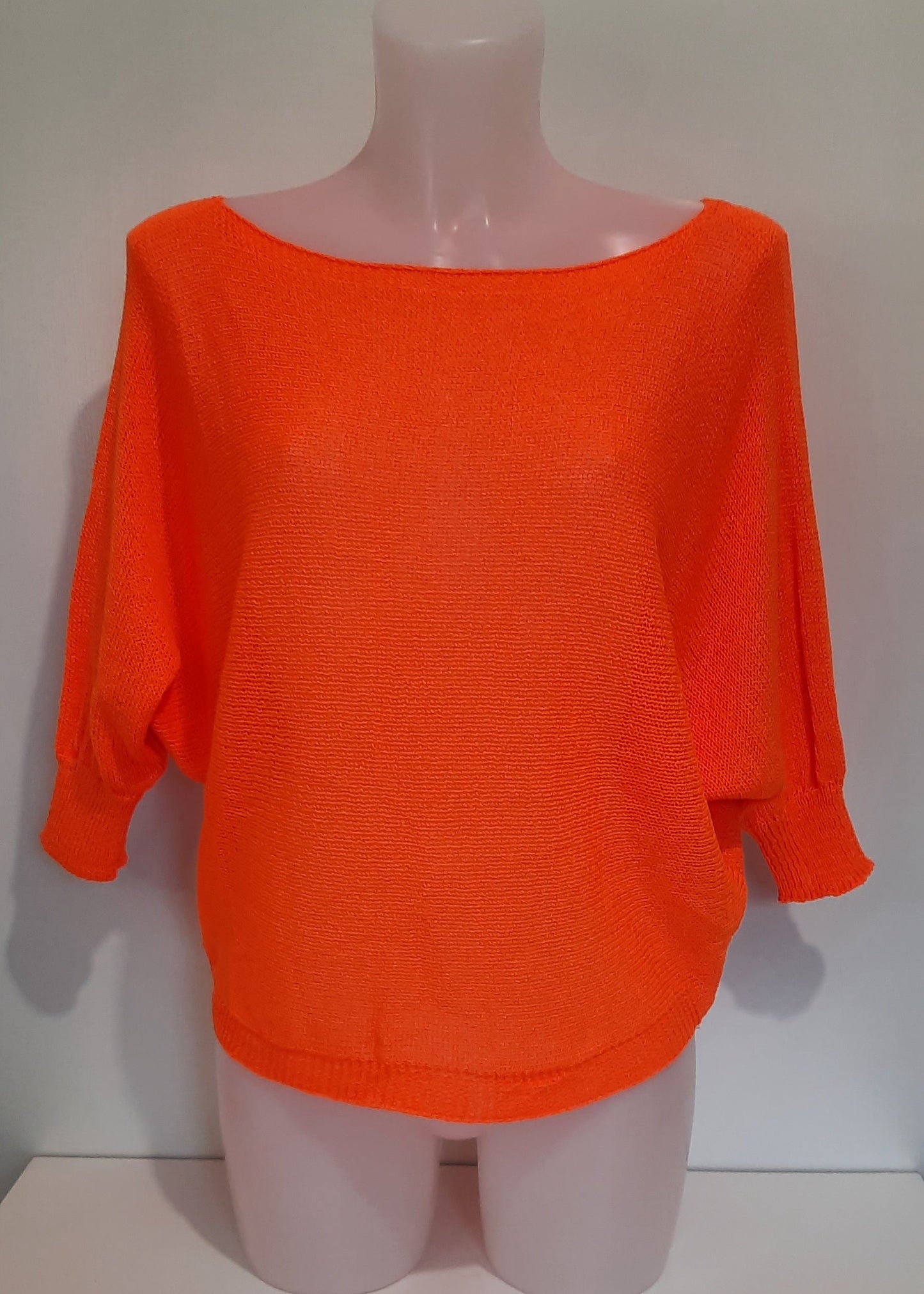 Haut en maille fine orange pour femme, manches 3/4 chauve-souris et encolure bateau. Coupe fluide et légère, parfaite pour le printemps ou l’été.