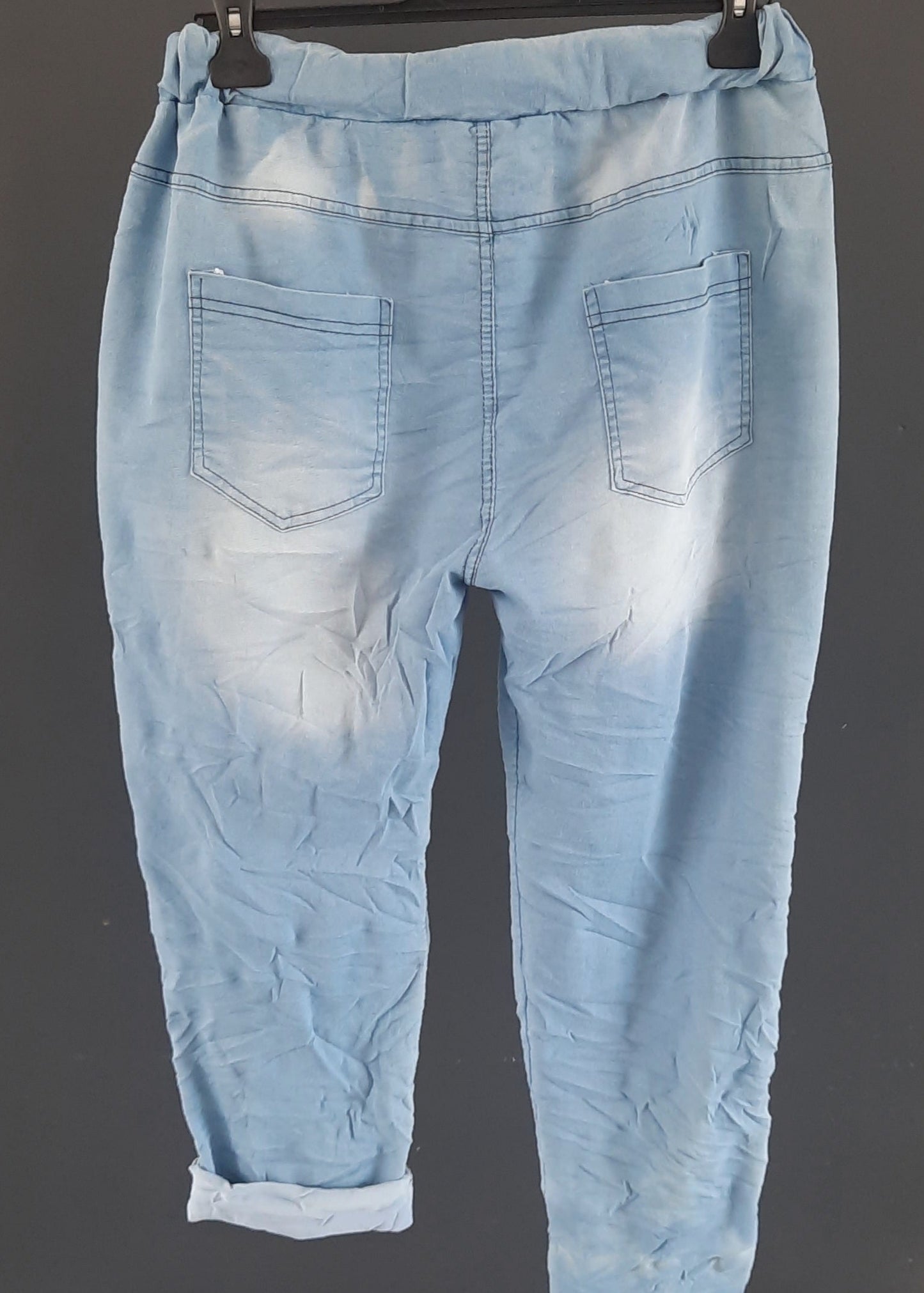 Pantalon jogger bleu clair pour femme, coupe décontractée avec taille élastique et lien à nouer, décoré de patchs à sequins argentés dont une étoile brillante. Style casual tendance avec une touche d’originalité.