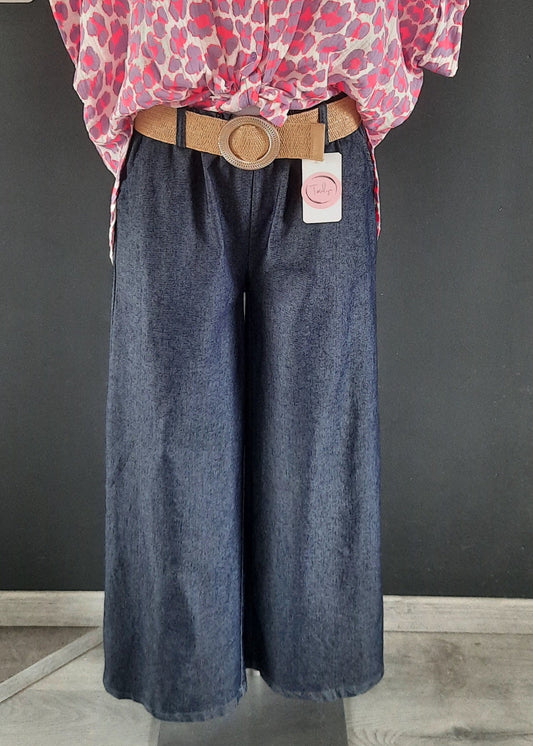 Pantalon large en denim léger foncé, coupe fluide style palazzo, ceinture élastique tressée beige avec boucle ronde dorée. Look décontracté chic, parfait pour le printemps et l’été.