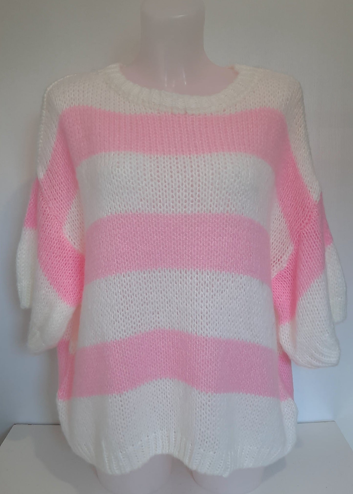 Pull oversize à manches courtes en maille tricotée, rayé rose et blanc. Coupe loose pour un look fun, vitaminé et confortable.