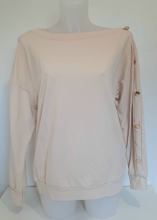 Sweat beige clair pour femme, coupe droite avec boutons dorés décoratifs sur l’épaule et le long de la manche. Style casual chic avec une touche d’originalité.