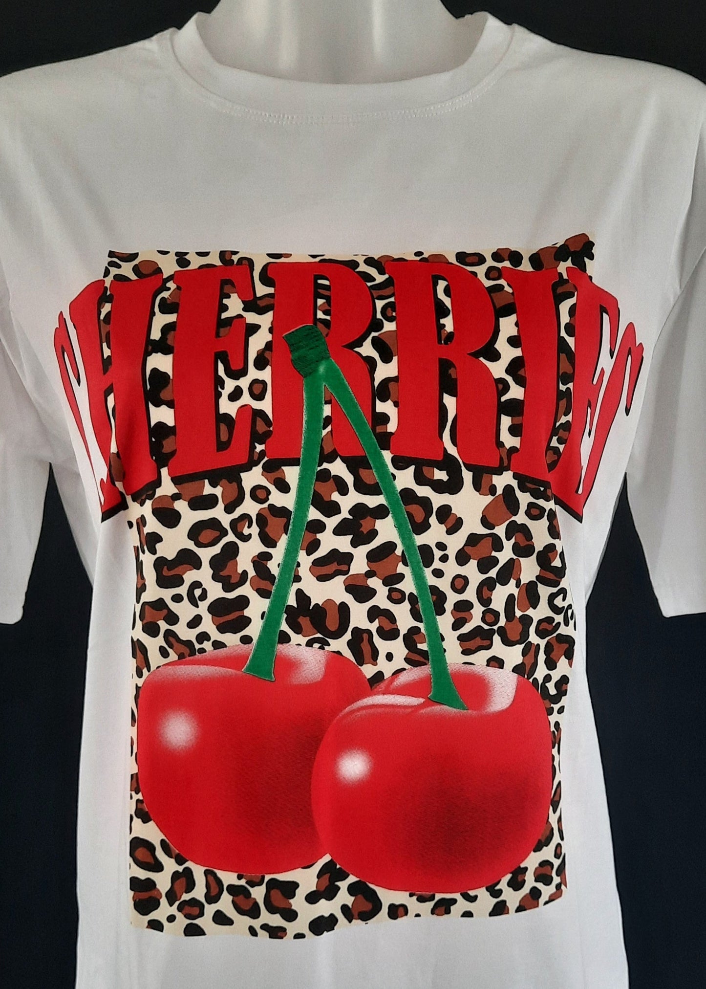 T-shirt blanc “CHERRIES” en lettres rouges avec cerises XXL sur fond léopard, coupe droite confortable, 95 % coton 5 % élasthanne, tailles S/M 36-38 et M/L 40-42, fabriqué en Chine, style rétro-pop fun
