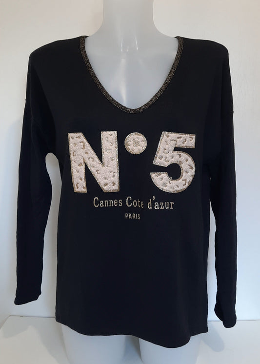 T-shirt noir à manches longues pour femme, col en V avec bord lurex doré, inscription 'N°5 Cannes Côte d’Azur Paris' en relief léopard et doré. Style casual chic inspiré des tendances parisiennes.
