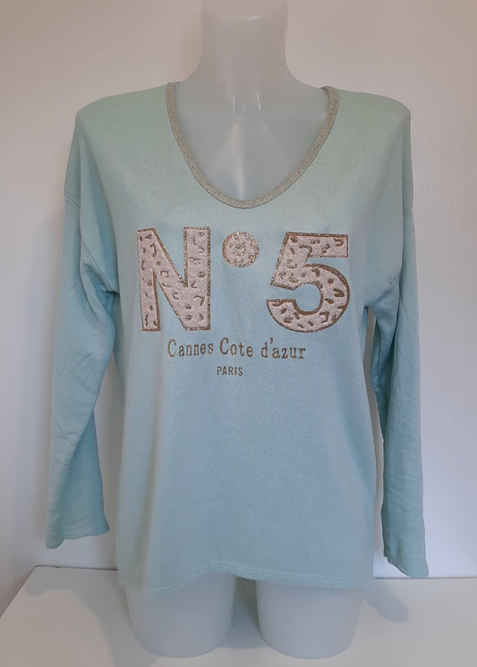 T-shirt vert d'eau à manches longues pour femme, col en V avec bord lurex doré, inscription 'N°5 Cannes Côte d’Azur Paris' en relief léopard et doré. Style casual chic inspiré des tendances parisiennes.