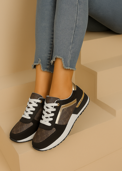 Baskets femme noires et marron avec détails dorés, imprimé monogramme doré, semelle blanche et noire, lacets blancs et œillets dorés. Un modèle chic et urbain – collection Timalya chaussures.