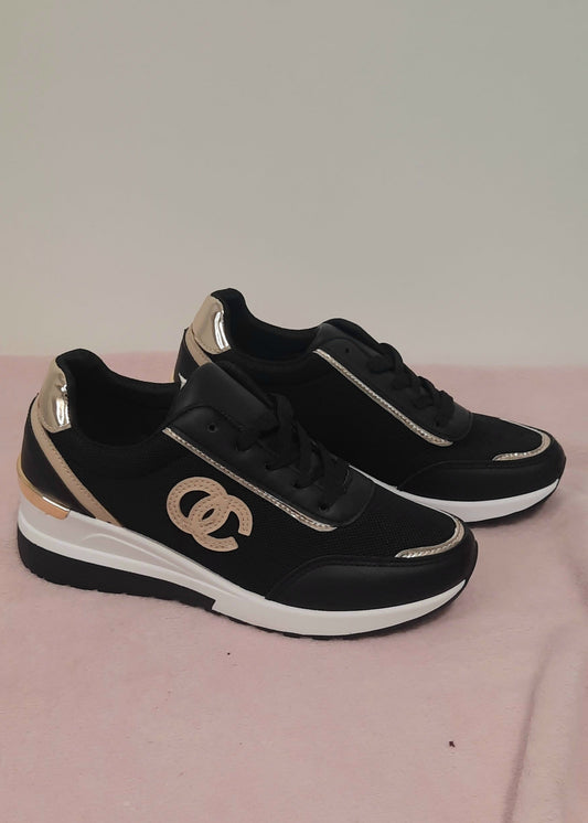 Baskets femme noires compensées avec logo entrelacé taupe, finitions dorées au talon et surpiqûres, semelle blanche compensée, style chic et urbain – Timalya.