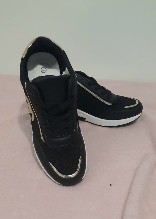 Baskets femme noires compensées avec logo entrelacé taupe, finitions dorées au talon et surpiqûres, semelle blanche compensée, style chic et urbain – Timalya.