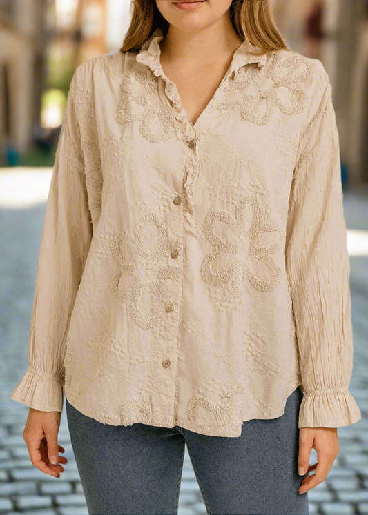 Blouse romantique beige pour femme avec broderies florales en relief et col à volants – manches longues bouffantes et fermeture boutonnée, parfaite pour un look chic et bohème. 