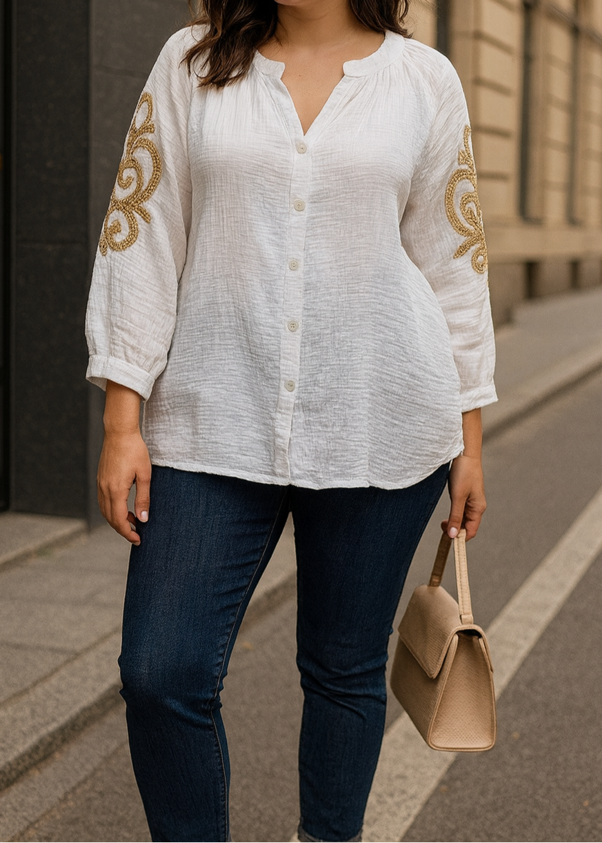 Blouse blanche en gaze de coton pour femme, manches 3/4 avec broderies dorées sur les bras, encolure tunisienne et boutonnage frontal. Style bohème chic et léger.