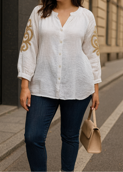 Blouse blanche en gaze de coton pour femme, manches 3/4 avec broderies dorées sur les bras, encolure tunisienne et boutonnage frontal. Style bohème chic et léger.
