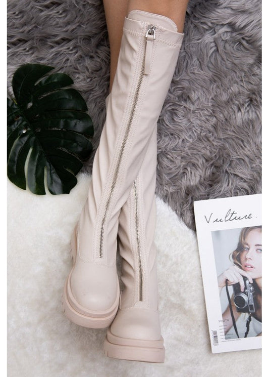 Bottes beiges pour femme en simili cuir, fermeture zippée à l’avant, semelle plateforme crantée et hauteur au-dessous du genou. Bottes tendance et confortables signées Timalya, parfaites pour un look urbain et moderne.