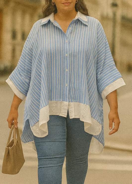 Chemise ample femme bleu ciel à rayures blanches, col classique, manches 3/4 boutonnées, détails en broderie anglaise blanche sur le col, les poignets et le bas.