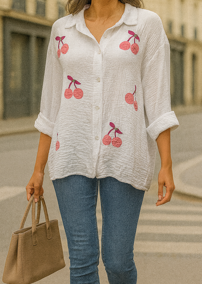 Chemise blanche en gaze de coton pour femme, ornée de broderies cerises roses avec strass – modèle à manches longues retroussables et col classique pour un style estival et ludique.
