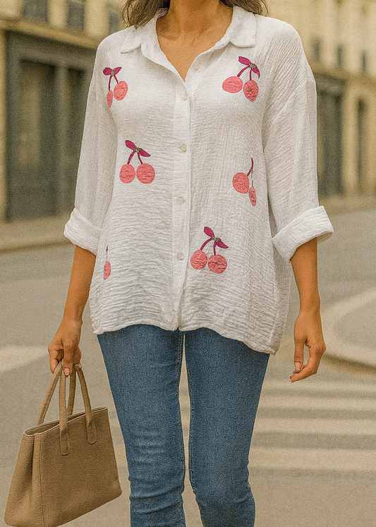 Chemise blanche en gaze de coton pour femme, ornée de broderies cerises roses avec strass – modèle à manches longues retroussables et col classique pour un style estival et ludique.