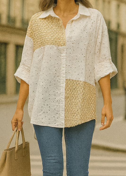 Chemise blanche en broderie anglaise avec empiècements en crochet doré sur l’épaule, le devant et le bas. Manches retroussables, coupe asymétrique pour un look bohème moderne.