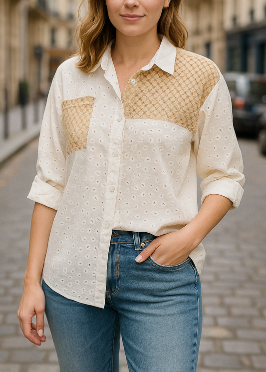 Chemise blanche en broderie anglaise avec empiècements en crochet doré sur l’épaule et la poitrine. Coupe ample, manches retroussables, style bohème chic parfait pour l'été.