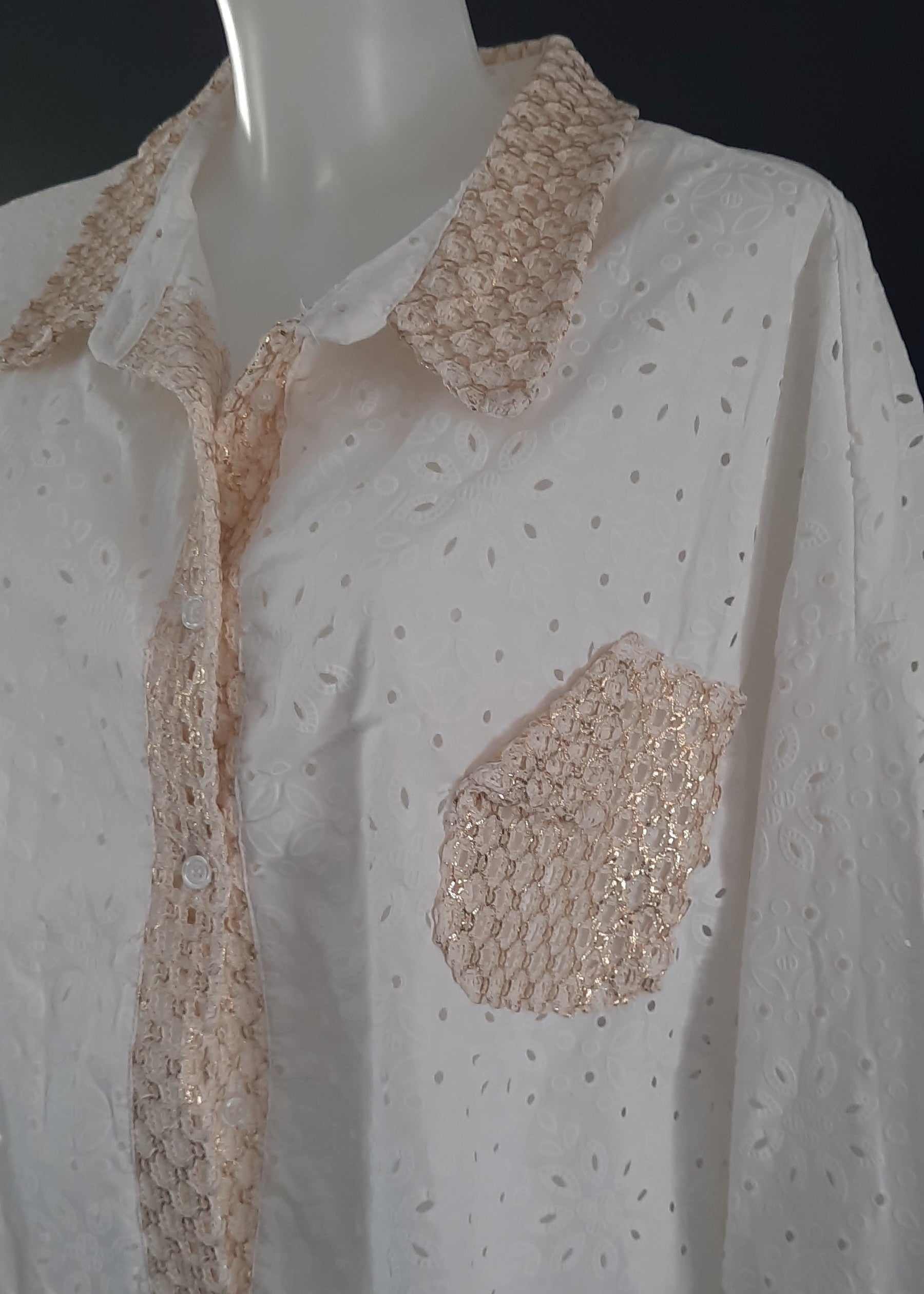 Chemise blanche en broderie anglaise pour femme, col, patte de boutonnage et poche en crochet doré. Coupe fluide et détails bohèmes raffinés.