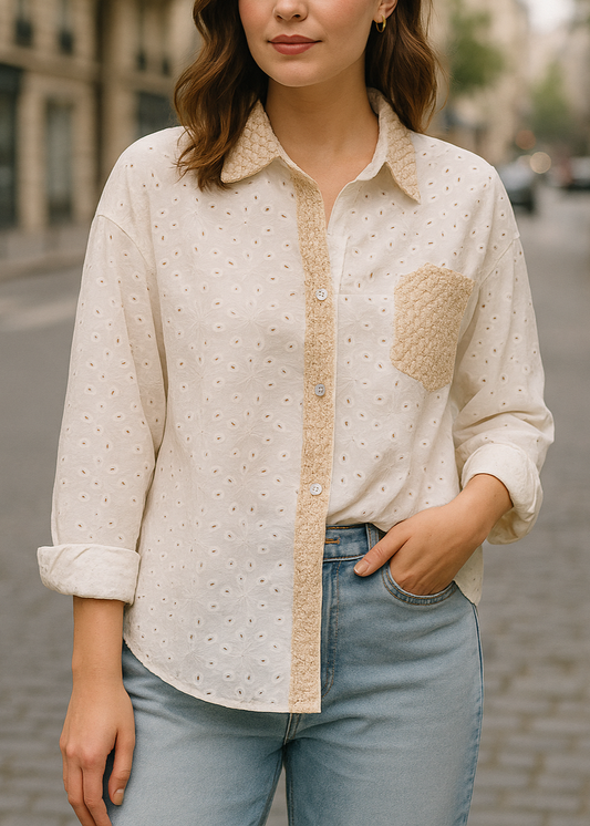 Chemise blanche en broderie anglaise pour femme, col, patte de boutonnage et poche en crochet doré. Coupe fluide et détails bohèmes raffinés.
