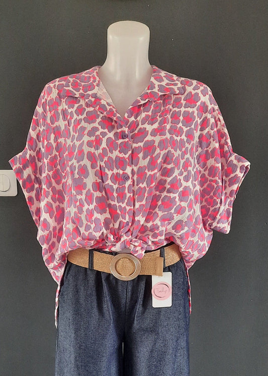 Chemise fluide à manches courtes pour femme, imprimé léopard rose et violet sur fond blanc, col classique, nouée à la taille pour un look tendance et estival.