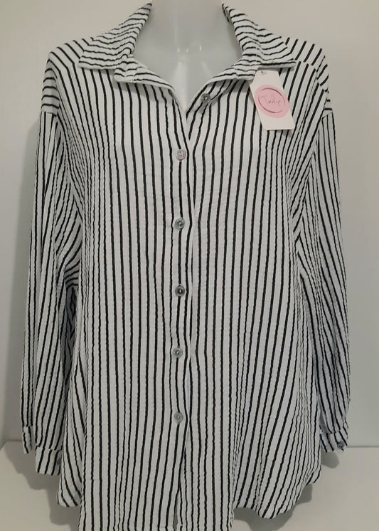 Chemise femme à rayures verticales noires et blanches en gaz de coton, coupe classique à col chemise et manches longues – un essentiel chic et intemporel pour un look professionnel ou décontracté.
