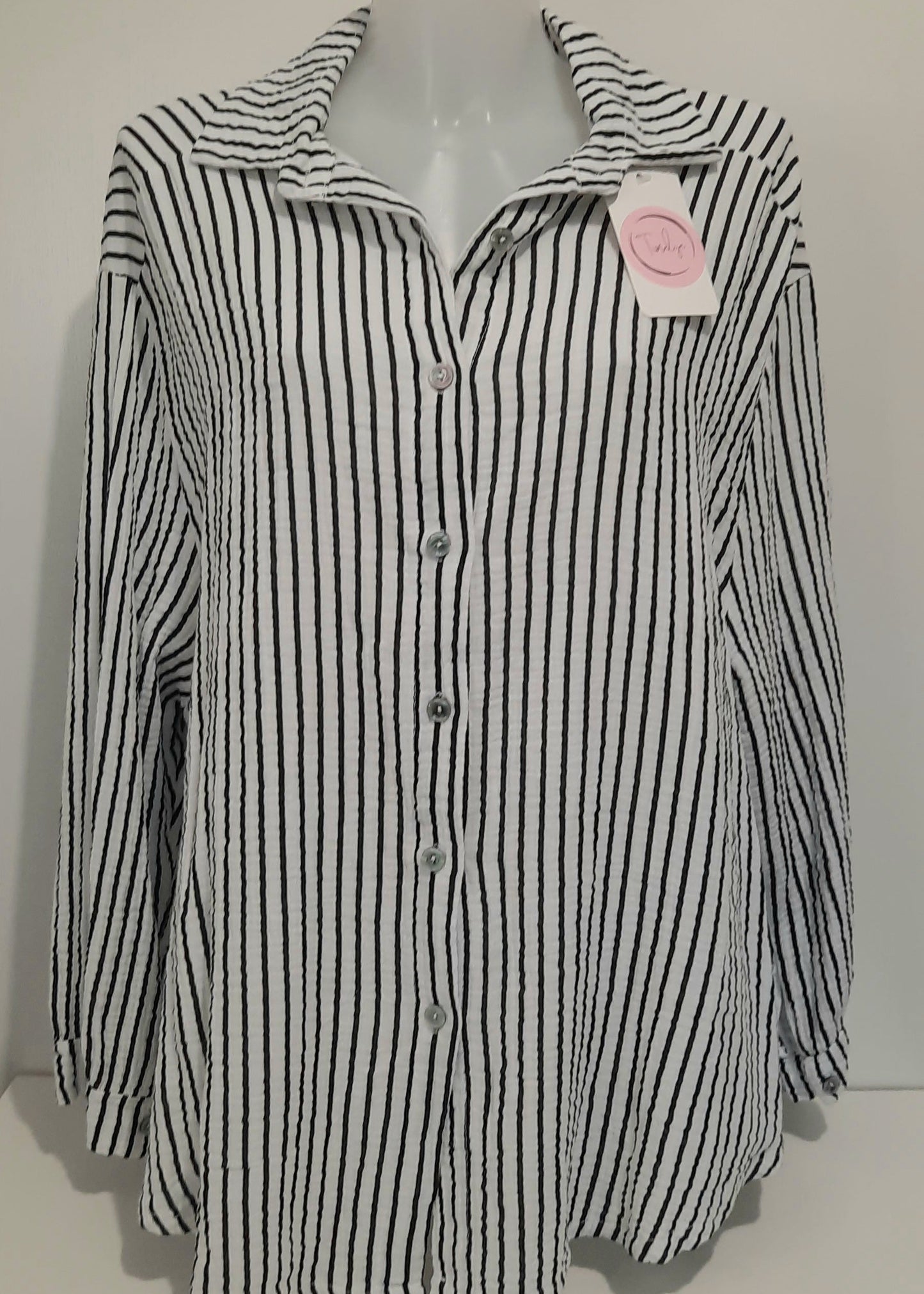 Chemise femme à rayures verticales noires et blanches en gaz de coton, coupe classique à col chemise et manches longues – un essentiel chic et intemporel pour un look professionnel ou décontracté.