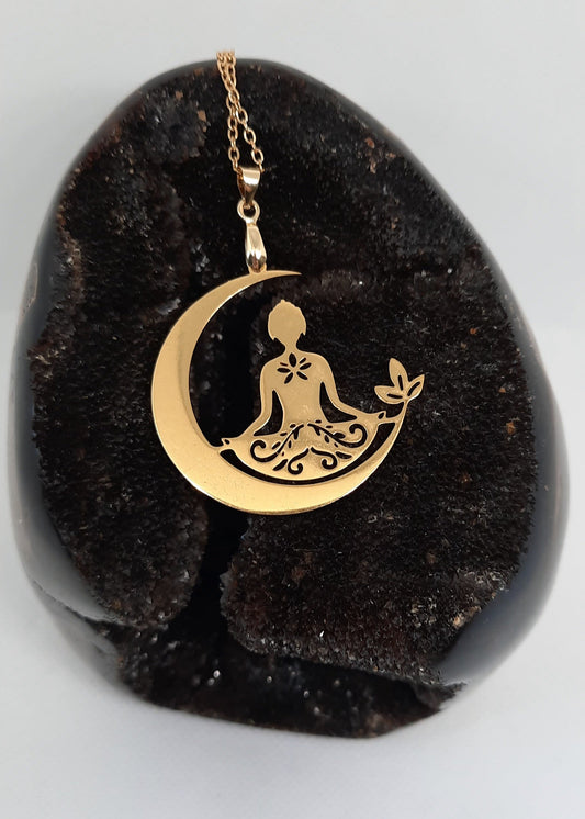 Collier bouddha en acier inoxydable doré, représentant une silhouette en méditation sur un croissant de lune avec décor floral, bijou zen et résistant