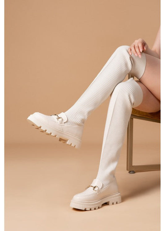 Cuissardes femme couleur beige combinant un mocassin à semelle crantée et une tige chaussette côtelée extensible. Détail chaîne dorée, style tendance et confortable, parfait pour un look citadin moderne – modèle Timalya.