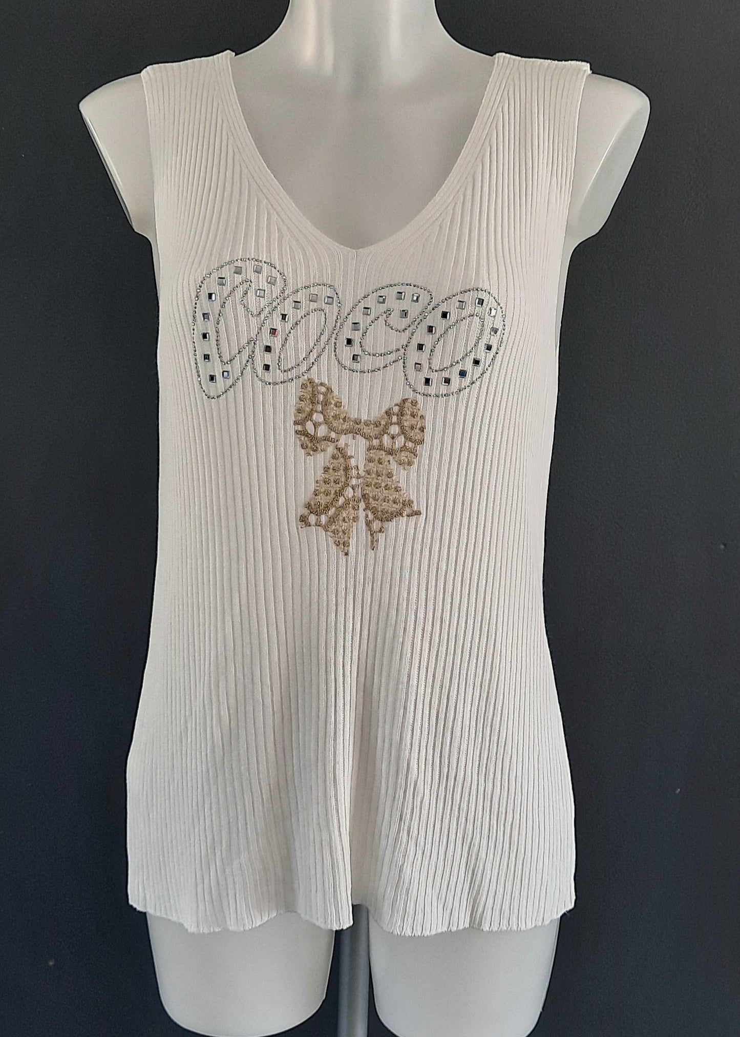 Débardeur blanc "COCO" en maille plissée, inscription en strass argentés avec nœud brodé doré, col V, coupe fluide légèrement évasée, 88 % viscose 12 % nylon, taille unique 36-46, longueur ~60 cm, style chic estival, fabrication Italie