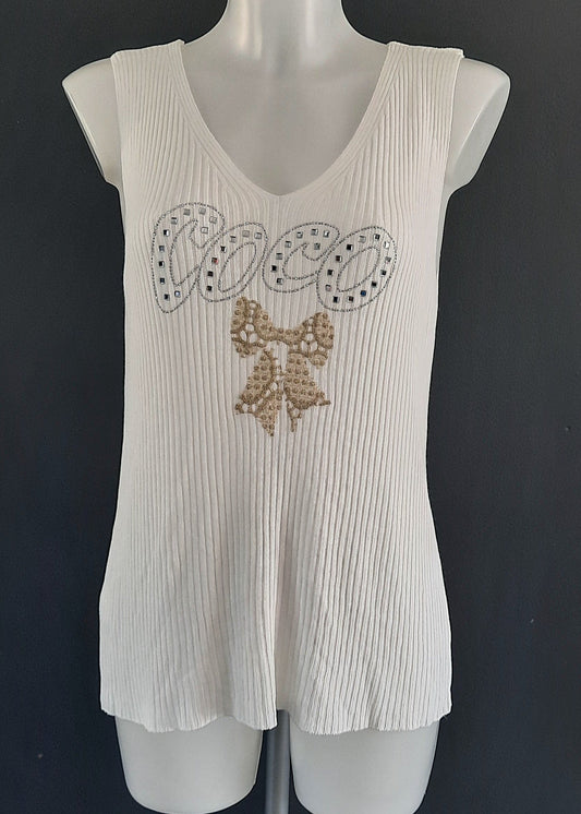 Débardeur blanc "COCO" en maille plissée, inscription en strass argentés avec nœud brodé doré, col V, coupe fluide légèrement évasée, 88 % viscose 12 % nylon, taille unique 36-46, longueur ~60 cm, style chic estival, fabrication Italie