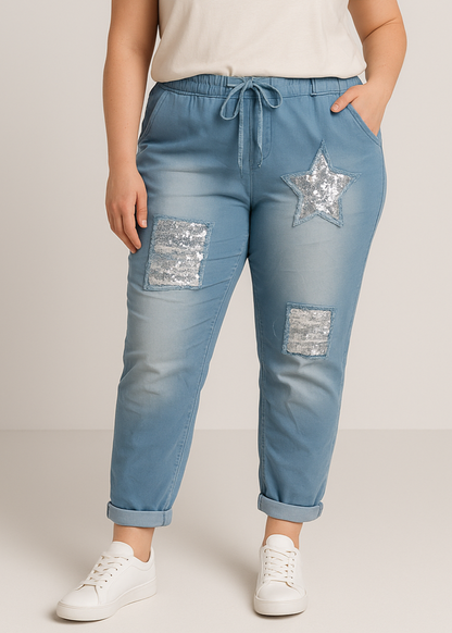 Pantalon jogger bleu clair pour femme, coupe décontractée avec taille élastique et lien à nouer, décoré de patchs à sequins argentés dont une étoile brillante. Style casual tendance avec une touche d’originalité.