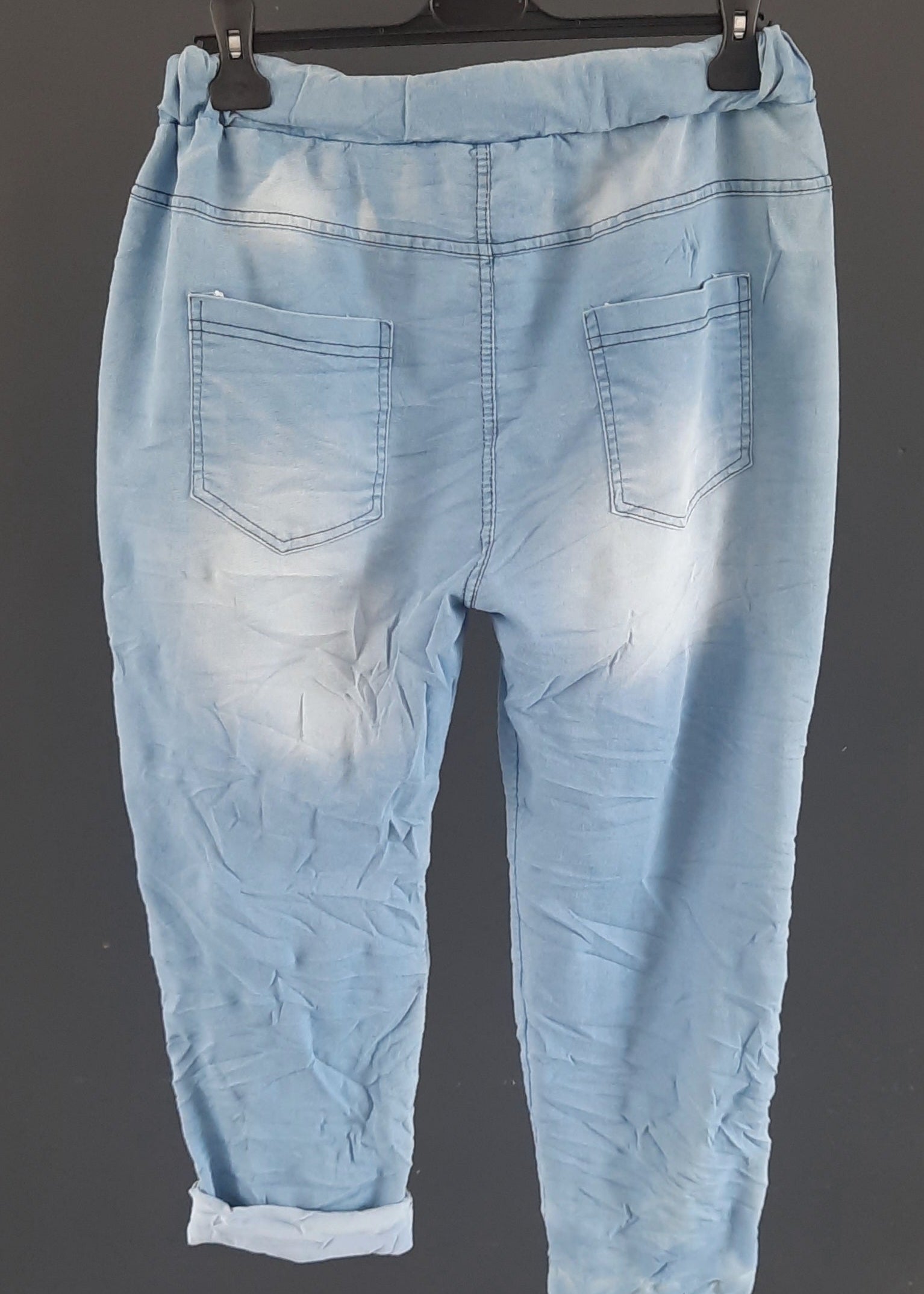 Pantalon jogging bleu clair pour femme, coupe décontractée avec taille élastique et lien de serrage, décoré de patchs brodés, clous et sequins argentés. Style streetwear tendance et confortable.