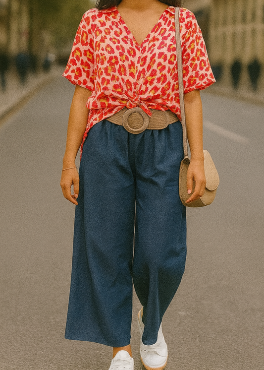 Pantalon large en denim léger clair, coupe fluide style palazzo, ceinture élastique tressée beige avec boucle ronde dorée. Look décontracté chic, parfait pour le printemps et l’été.