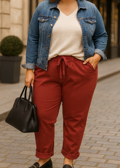 Pantalon magique femme coupe carotte en tissu fluide bordeaux, taille élastiquée avec cordon brillant à nouer, poches latérales et bas retroussés. Style décontracté et tendance.