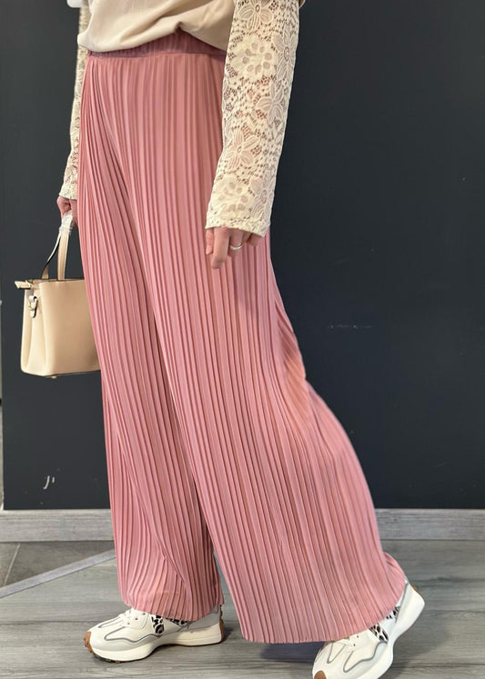 Pantalon plissé rose poudré pour femme, coupe large et fluide avec taille élastiquée. Style élégant et aérien, idéal pour un look chic et confortable.
