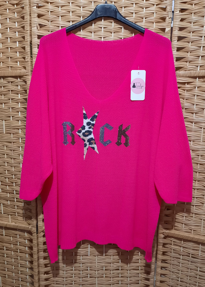 Pull femme fuchsia style rock, col V et manches 3/4 en maille douce oversize, motif “ROCK” avec étoile léopard pailletée sur le devant, idéal avec un pantalon blanc.