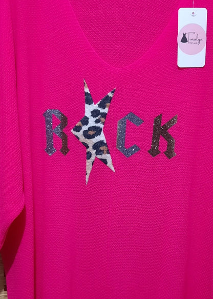 Pull femme fuchsia style rock, col V et manches 3/4 en maille douce oversize, motif “ROCK” avec étoile léopard pailletée sur le devant, idéal avec un pantalon blanc.