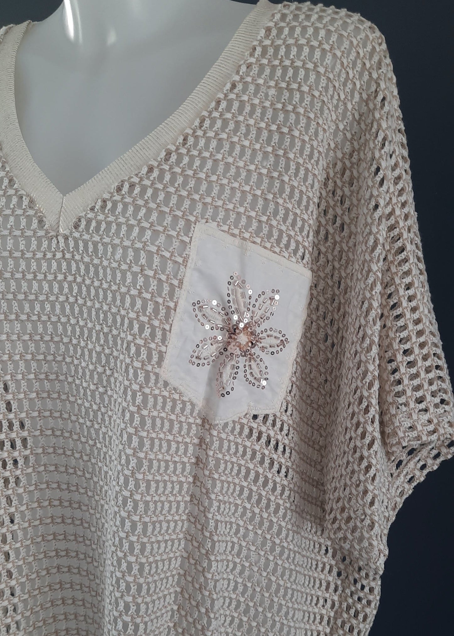 Top beige en maille ajourée avec poche brodée de fleur en perles, col V, manches courtes amples, coupe décontractée taille unique 42-50, 50 % coton 45 % modal 5 % élasthanne, fabrication Italie.