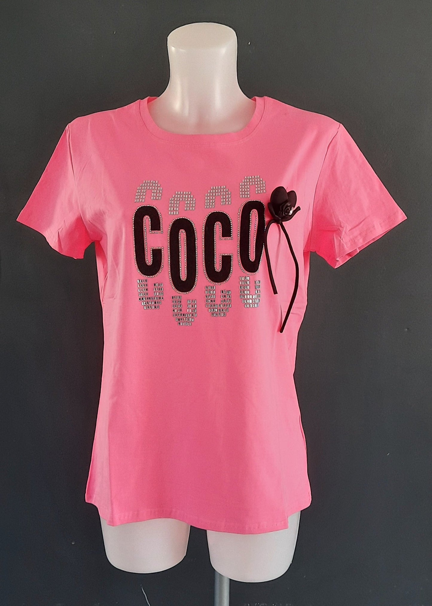 T-shirt fuchsia ajusté “COCO” avec strass argentés et nœud cœur noir amovible, col rond, 95 % coton 5 % élasthanne, tailles S/M (36–38) et M/L (38–40), longueur environ 61–62 cm, style urbain chic, fabriqué en Chine