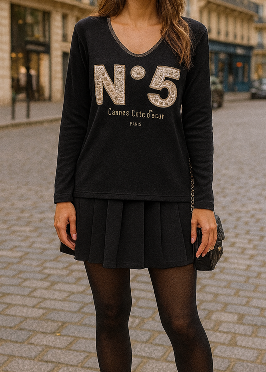 T-shirt noir à manches longues pour femme, col en V avec bord lurex doré, inscription 'N°5 Cannes Côte d’Azur Paris' en relief léopard et doré. Style casual chic inspiré des tendances parisiennes.