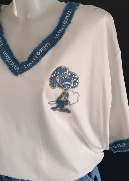 T-shirt blanc oversize “Snoopy” avec motif en denim et franges en jean sur col V et manches, inscription “LOVELY PUPPY”, 95 % viscose 5 % élasthanne, taille unique 42-48, longueur devant 71 cm arri. 76 cm, fabrication Italie