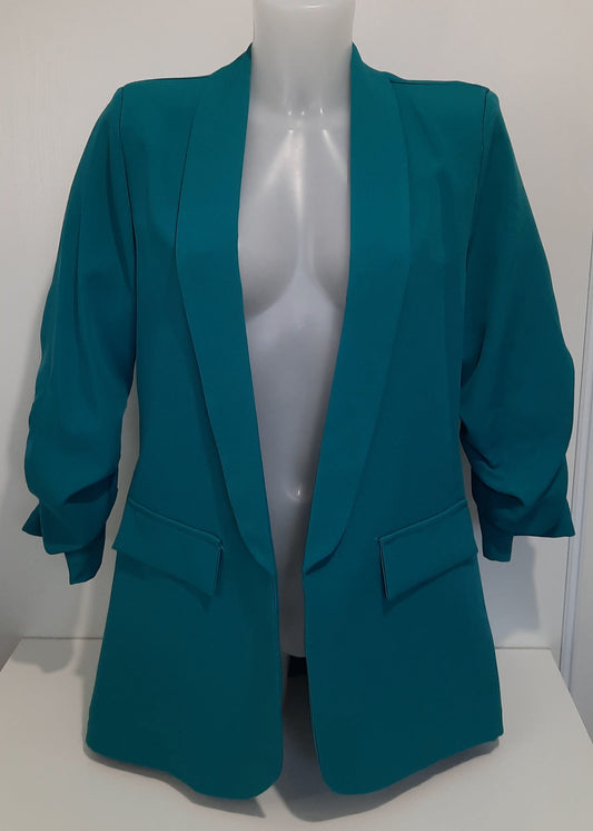 Veste tailleur pour femme de couleur bleu canard, coupe droite et fluide, avec manches 3/4 légèrement froncées, poches à rabat décoratives et revers élégants, parfaite pour un look chic, professionnel ou casual – modèle de la collection Timalya prêt-à-porter féminin tendance et moderne.